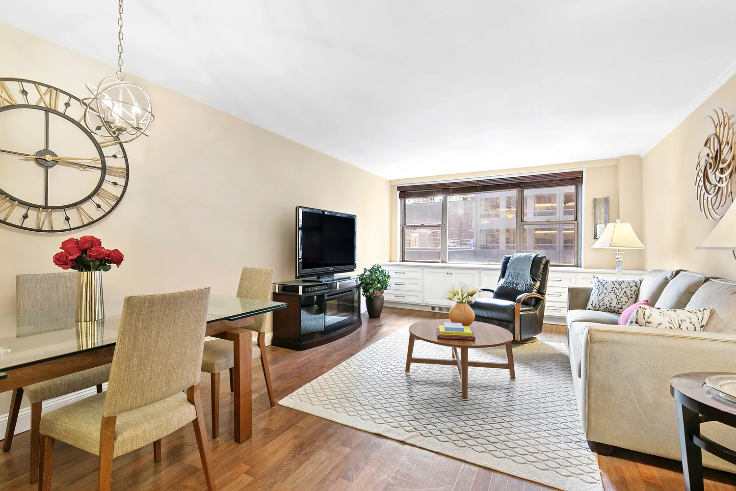 a living room with furniture a flat screen tv and a large window