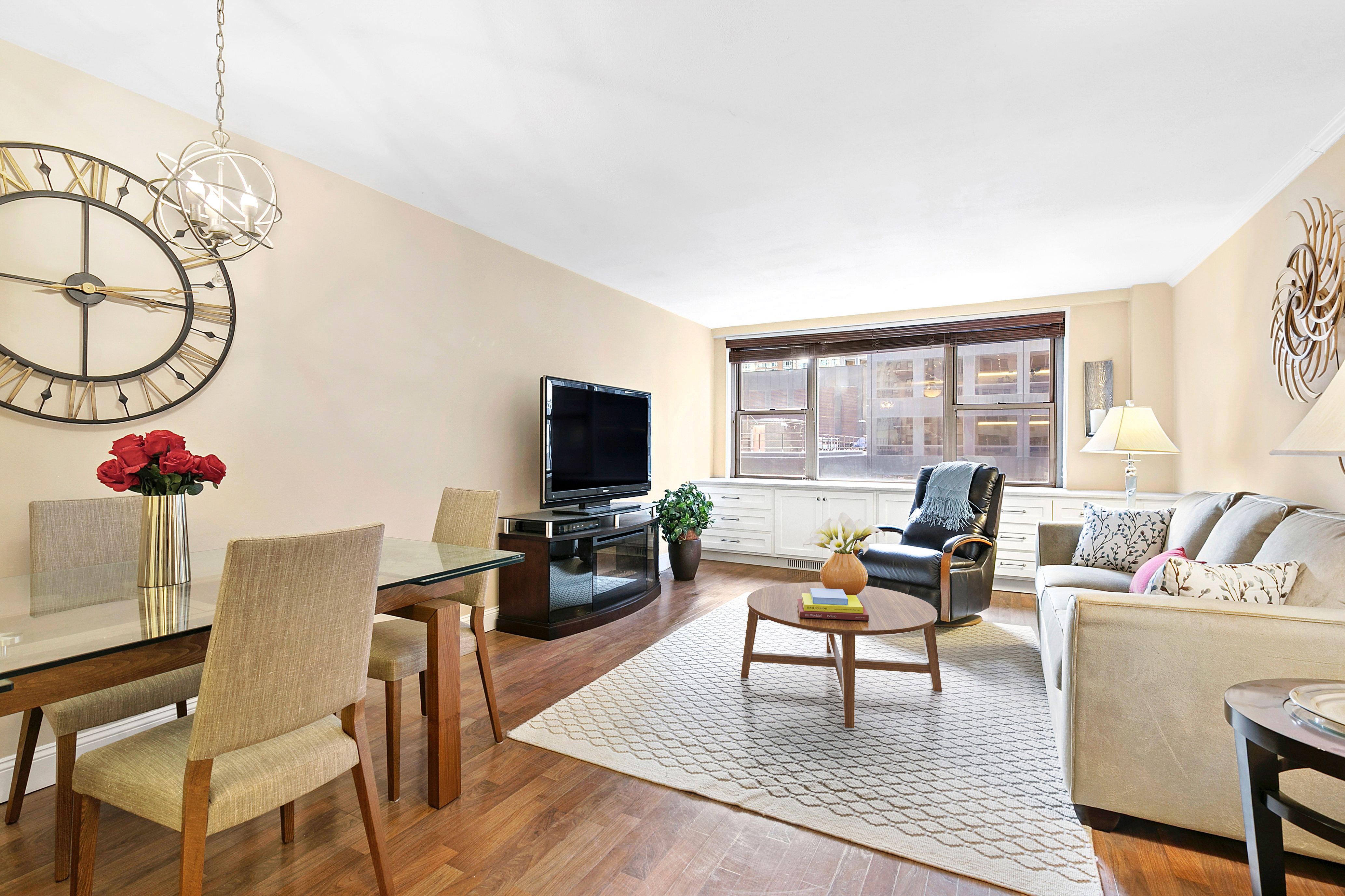 a living room with furniture a flat screen tv and a large window