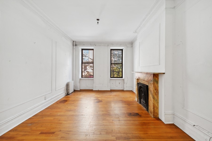206 East 90th Street, Unit 2E Manhattan, NY 10128 - Photo 2 of 13 an empty room with windows and a fireplace