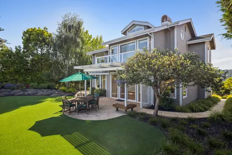 a view of a house with backyard porch and sitting area