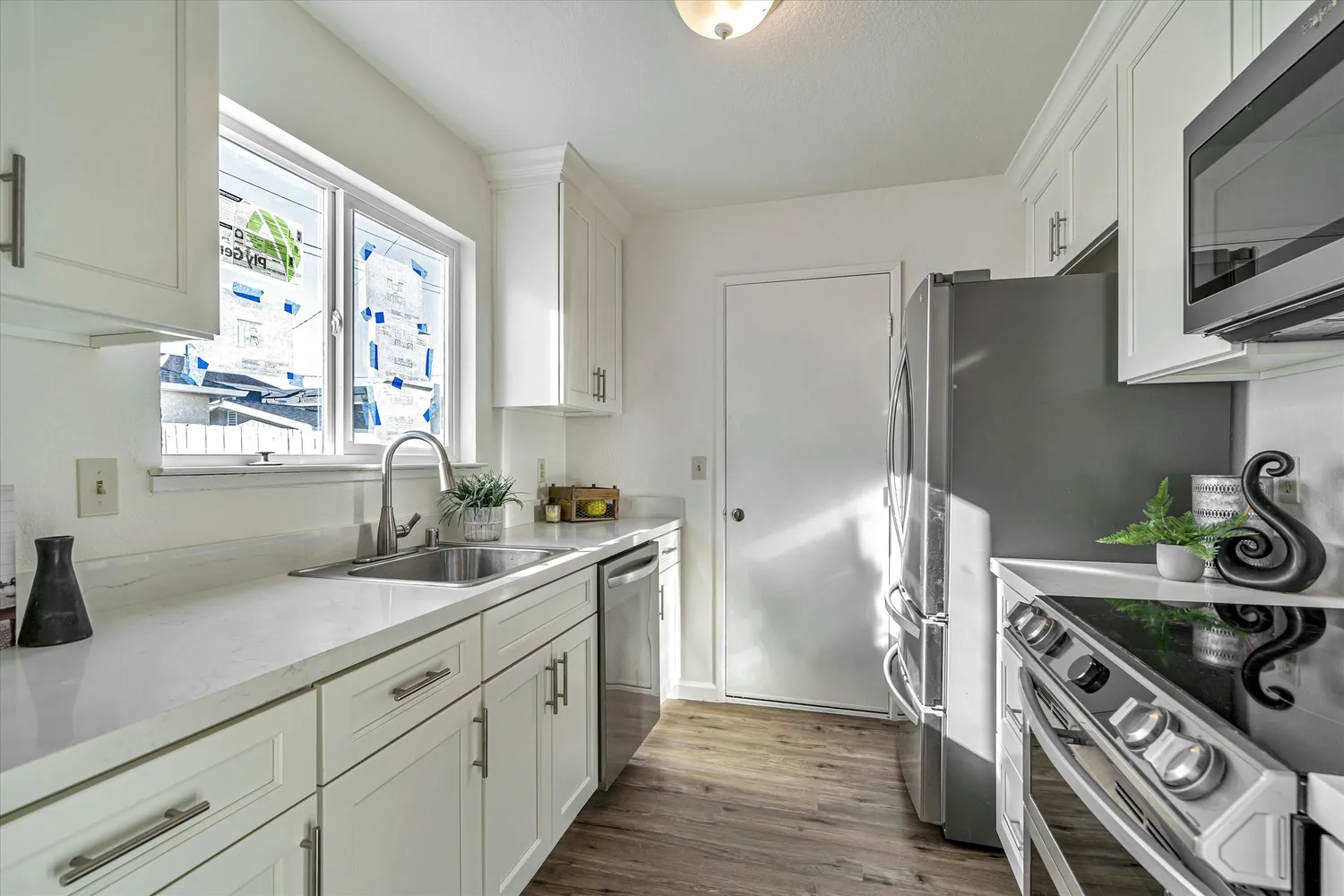 a kitchen with stainless steel appliances granite countertop white cabinets a stove top oven a sink and dishwasher