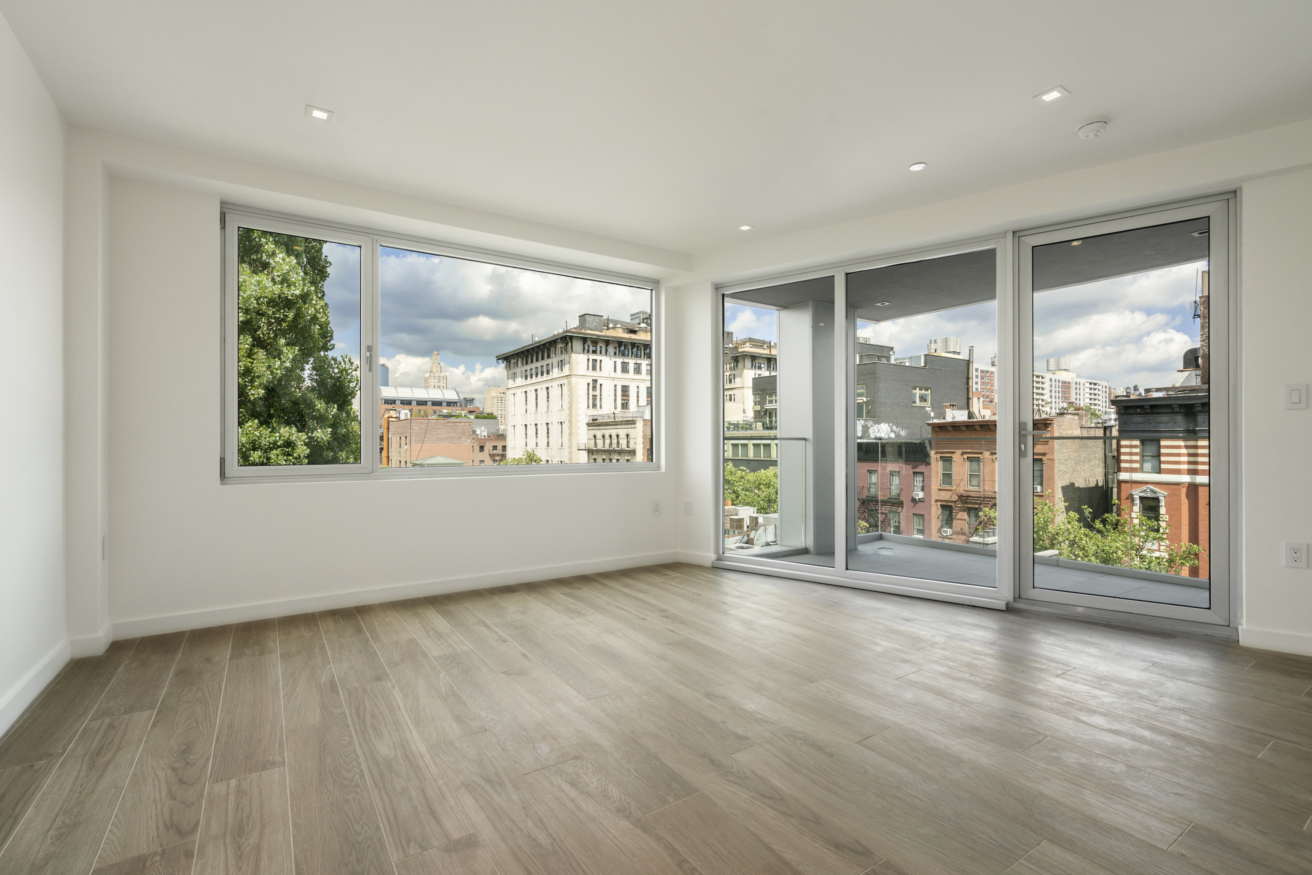 136 West Houston Street, Unit PH Manhattan, NY 10012 - Photo 13 of 26 an empty room with wooden floor and windows