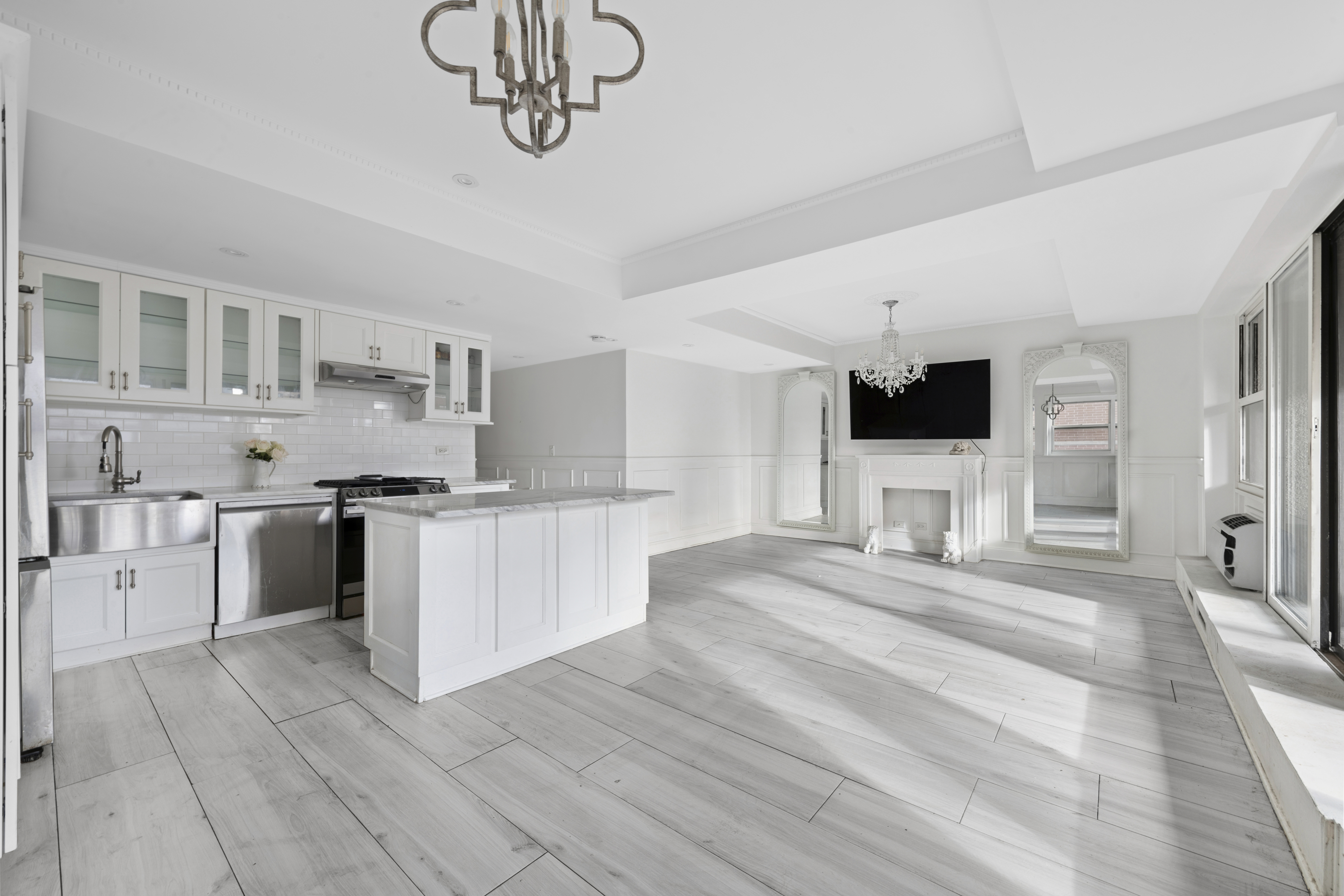 350 East 62nd Street, Unit PHD Manhattan, NY 10065 - Photo 3 of 15 a kitchen with stainless steel appliances kitchen island granite countertop a sink cabinets and wooden floor