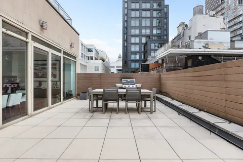 a view of a patio with a table and chairs next to a yard