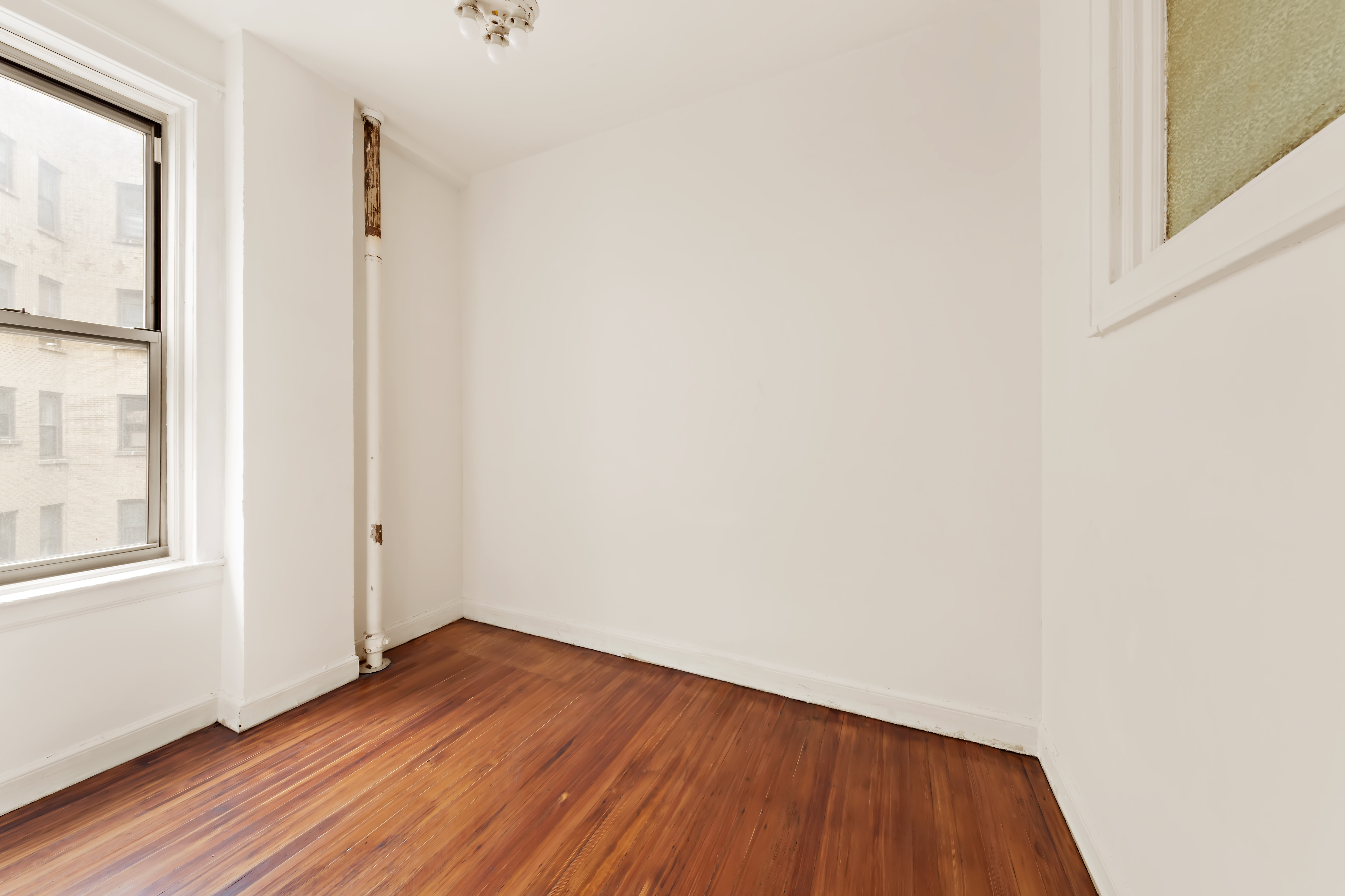 800 Riverside Drive, Unit 6E Manhattan, NY 10032 - Photo 15 of 30 a view of an empty room with wooden floor and a window