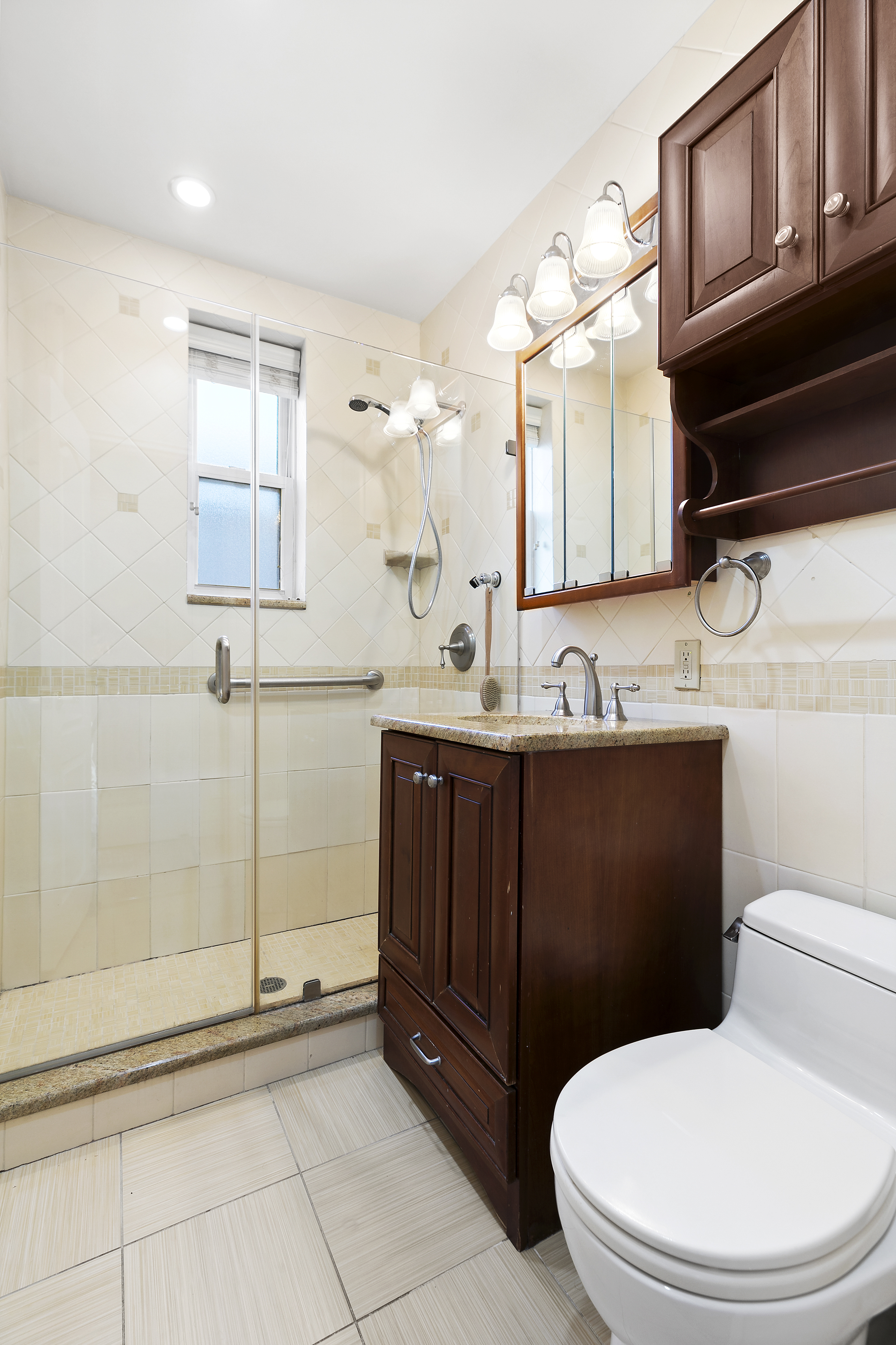 9801 Shore Road, Unit 5A Brooklyn, NY 11209 - Photo 10 of 11 a bathroom with a toilet a sink and mirror