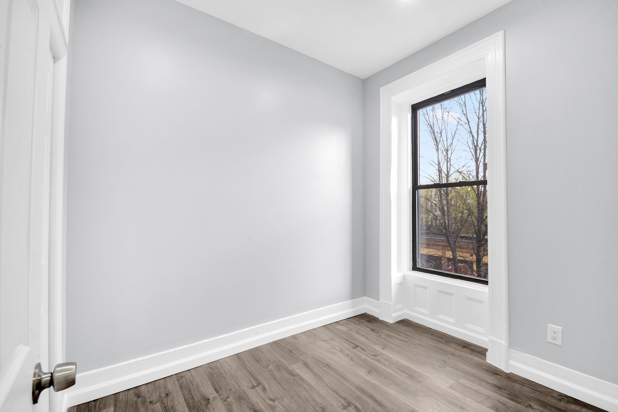 316 Lewis Avenue, Unit 2 Brooklyn, NY 11221 - Photo 6 of 8 an empty room with wooden floor and windows