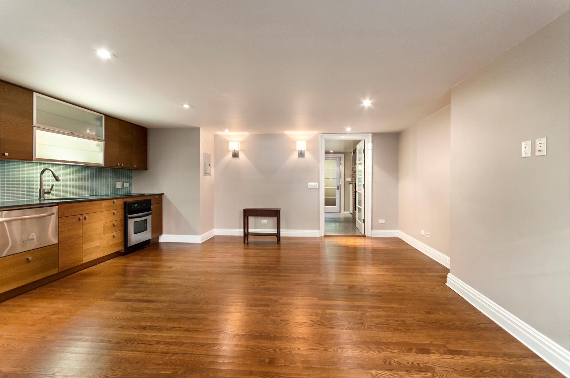 150 Dean Street, Unit 1 Brooklyn, NY 11217 - Photo 4 of 7 a view of an empty room with wooden floor and a kitchen
