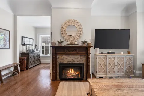 a living room with fireplace furniture a flat screen tv and a fireplace