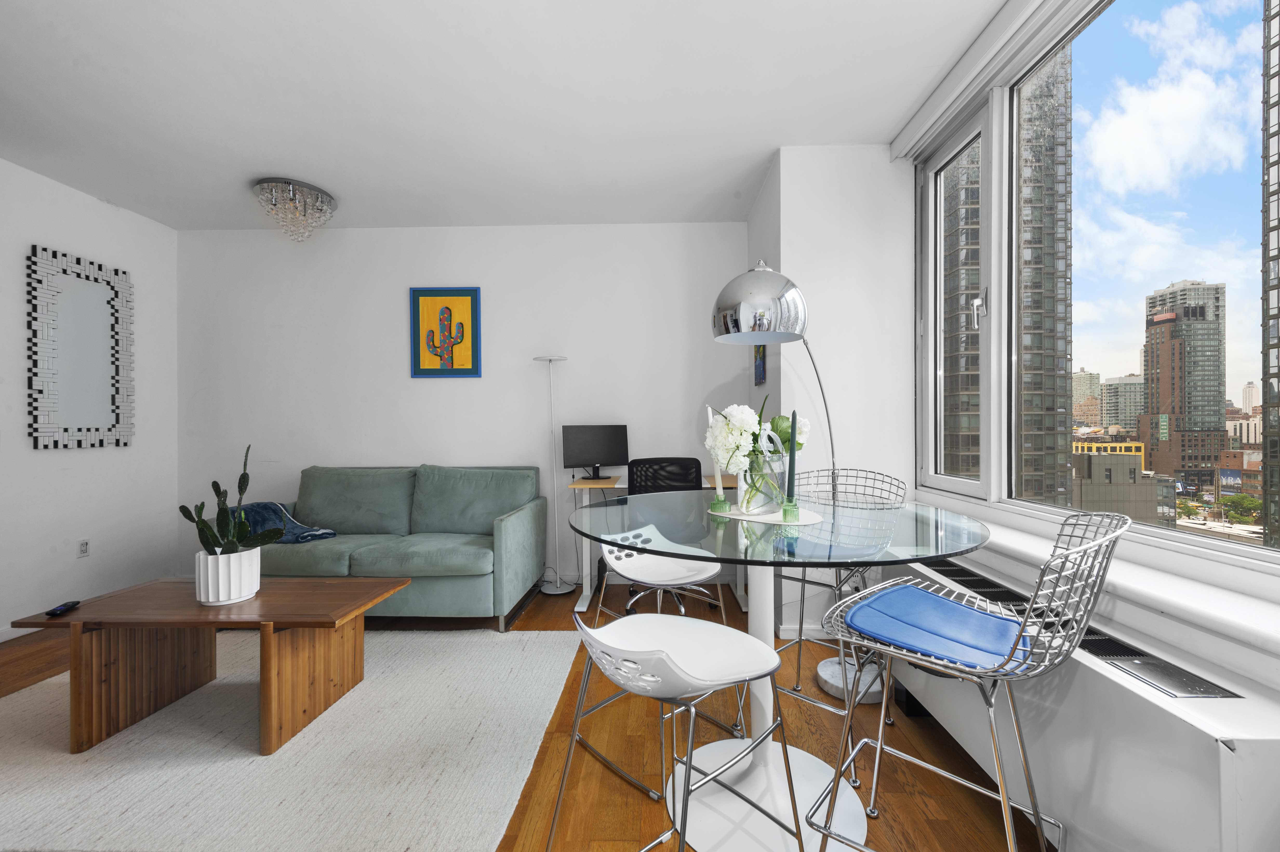 635 West 42nd Street, Unit 14K Manhattan, NY 10036 - Photo 5 of 19 a living room with furniture and a floor to ceiling window