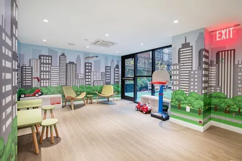 a playing room with furniture and a floor to ceiling window