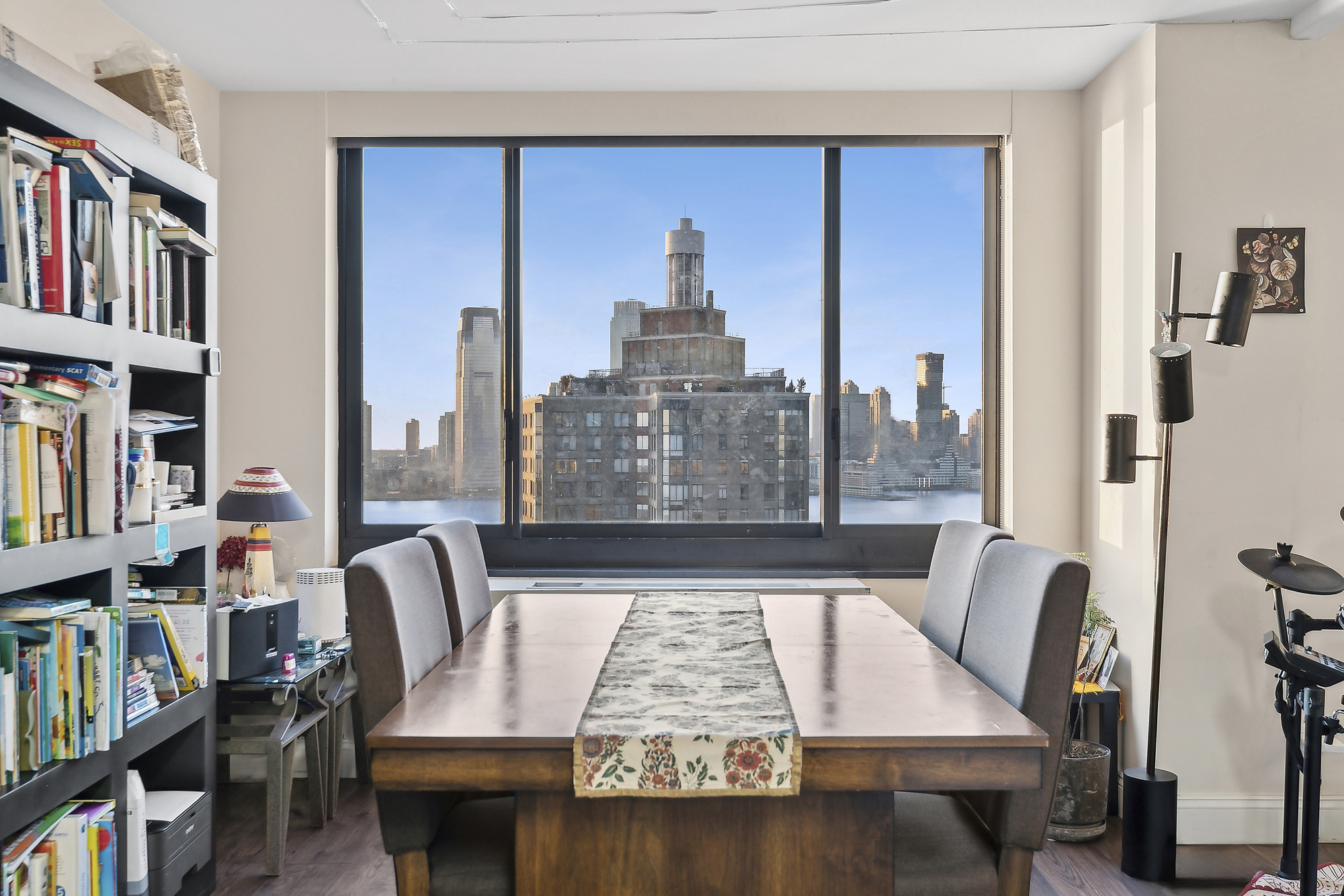200 Rector Place, Unit 26B Manhattan, NY 10280 - Photo 2 of 8 a view of a workspace with furniture and a book shelf