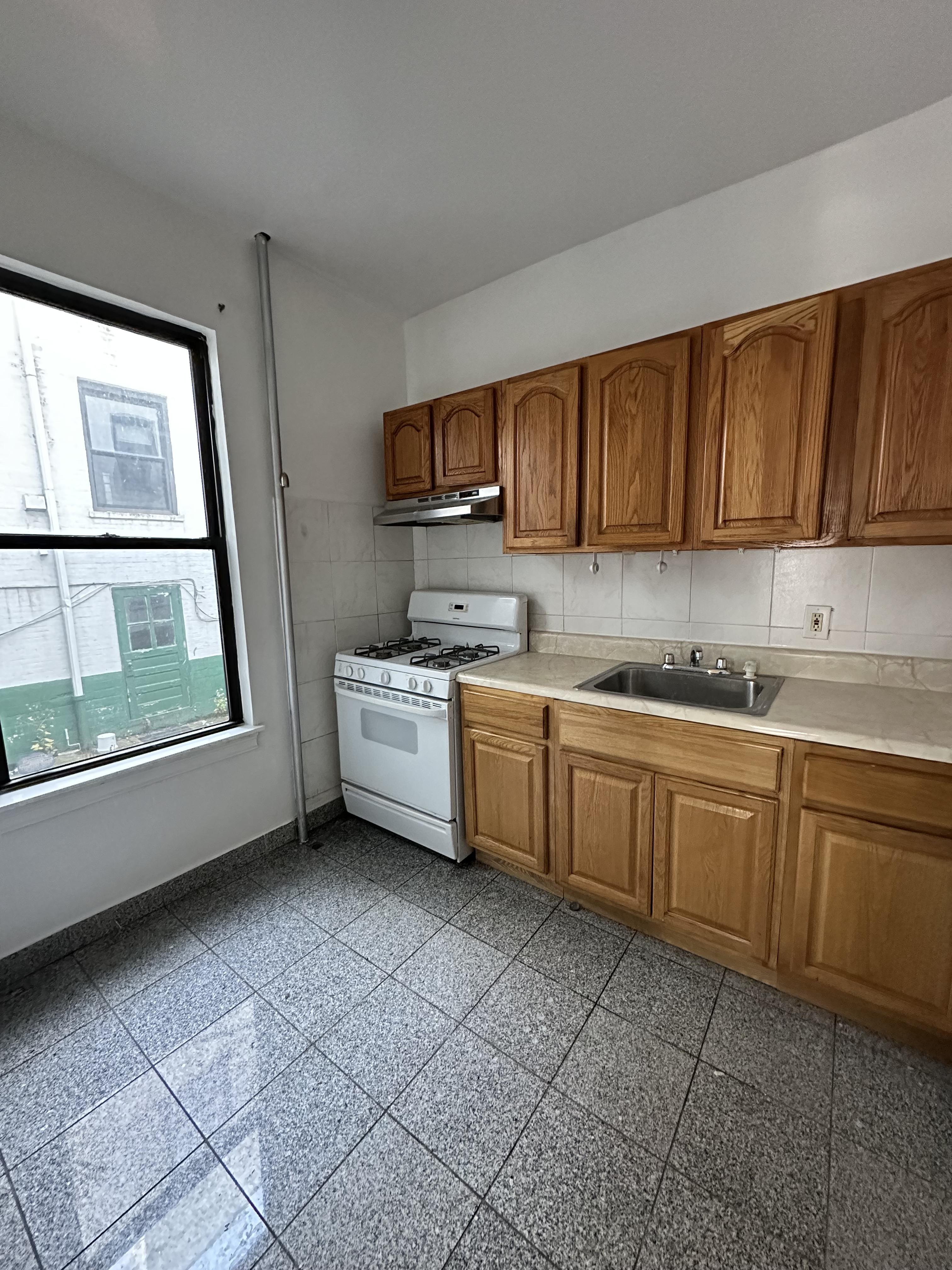 31-40 42nd Street, Unit 1F Queens, NY 11103 - Photo 8 of 9 a kitchen with a sink a stove and cabinets