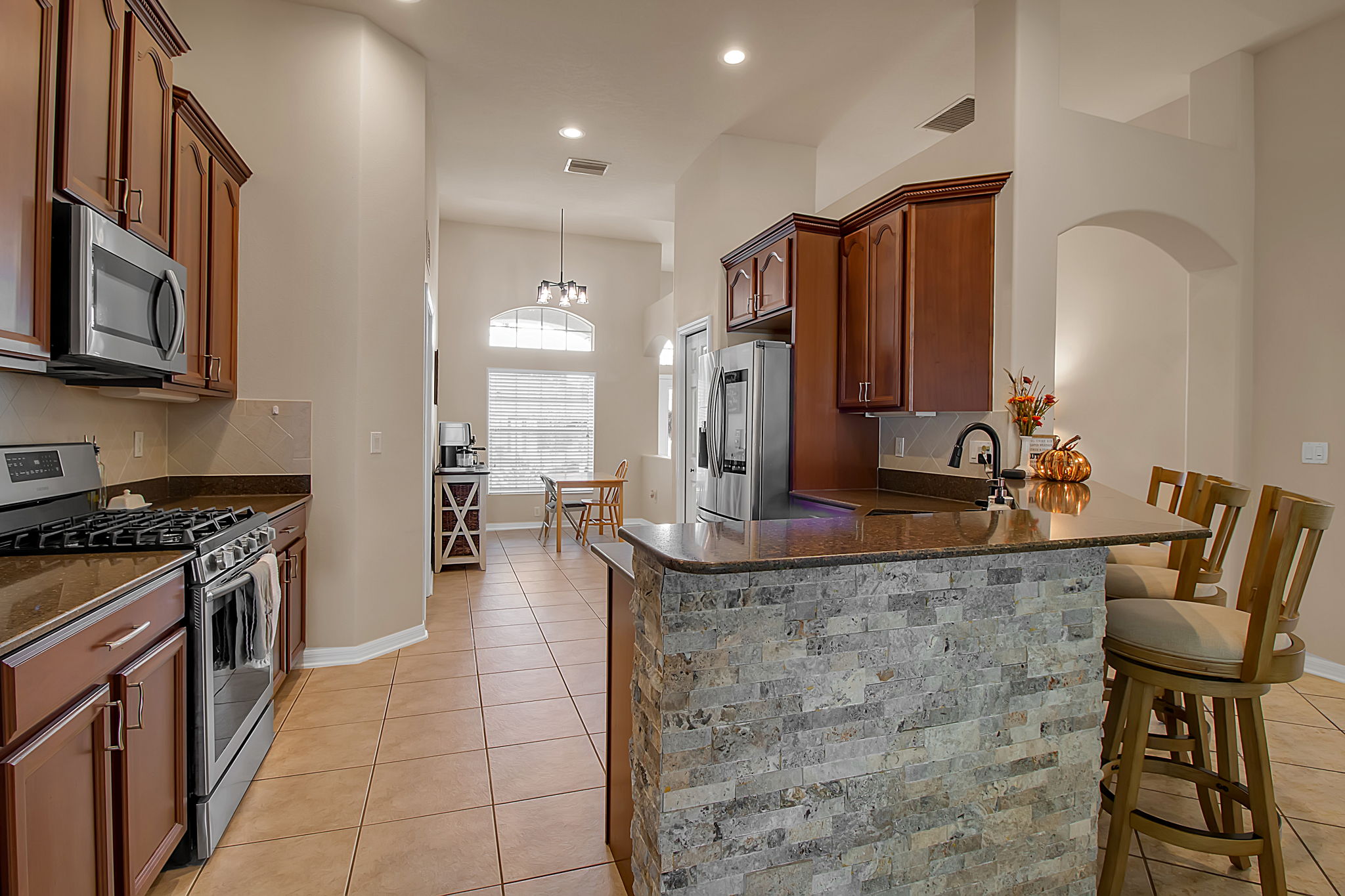 6106 34th Court East Bradenton, FL 34203 - Photo 27 of 69 a kitchen with kitchen island granite countertop a stove and a sink