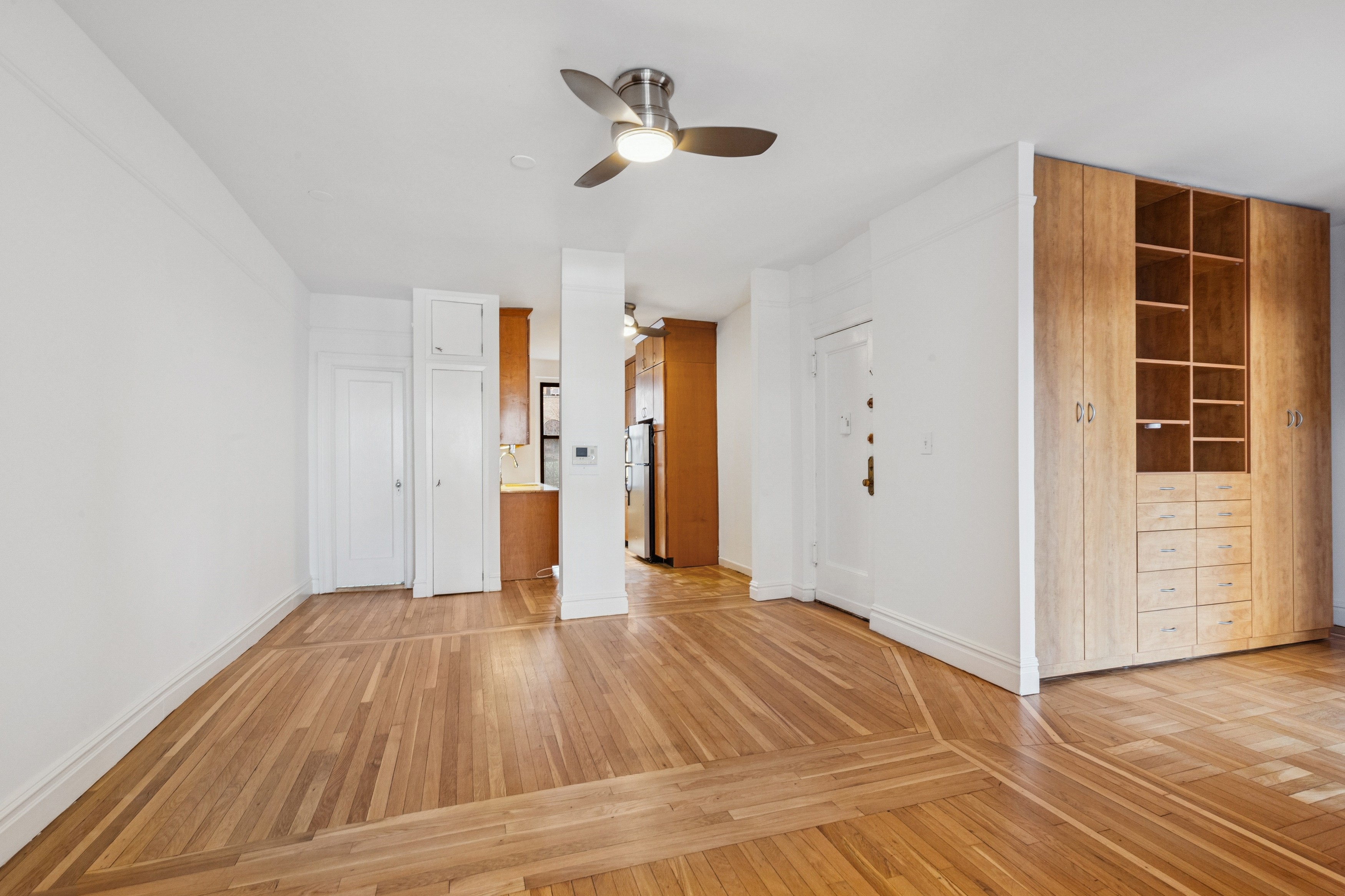 115 Cabrini Boulevard, Unit B51 Manhattan, NY 10033 - Photo 5 of 23 a view of empty room with wooden floor and ceiling fan
