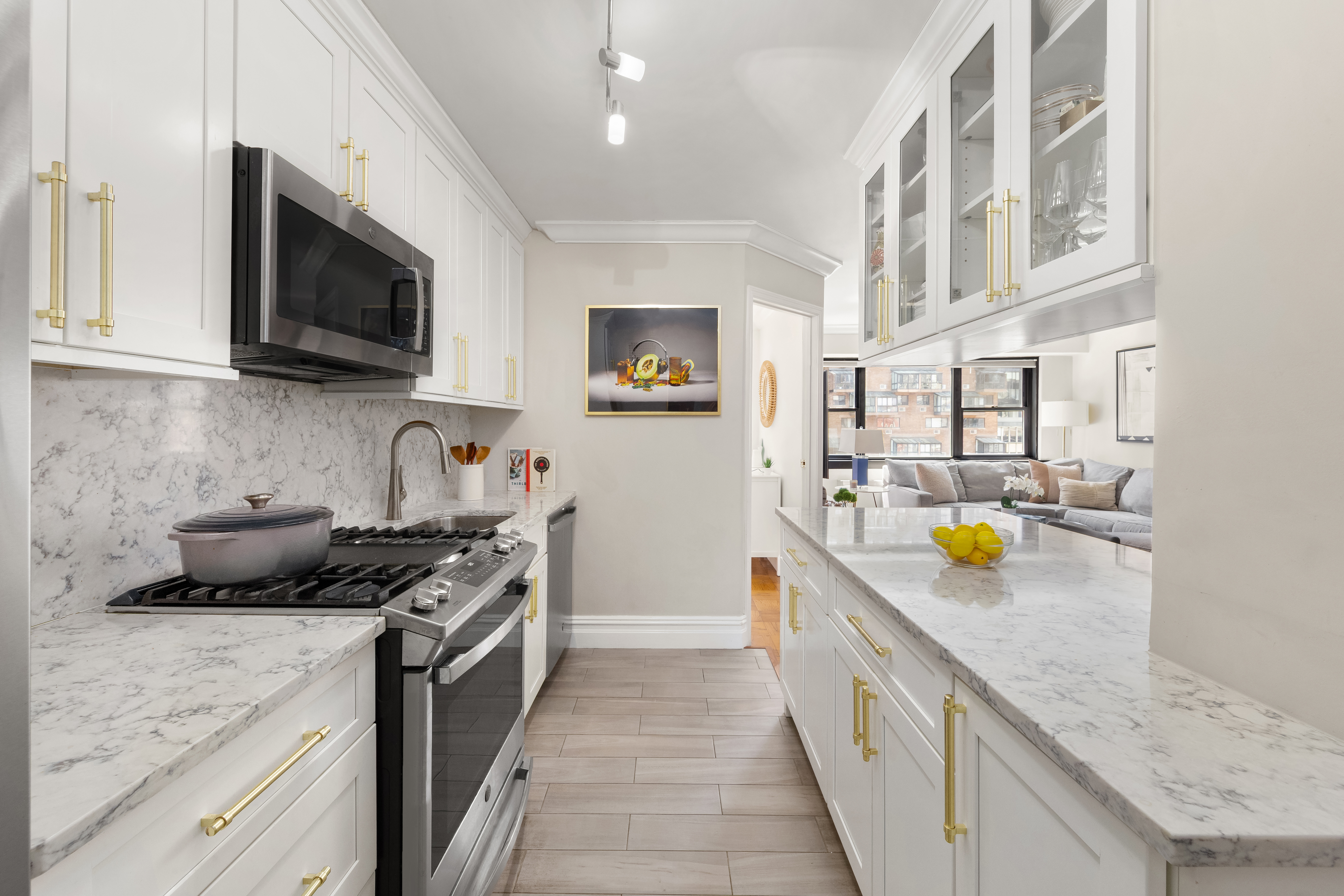 235 East 87th Street, Unit 10B Manhattan, NY 10128 - Photo 4 of 12 a kitchen with stainless steel appliances granite countertop a stove a sink and a microwave