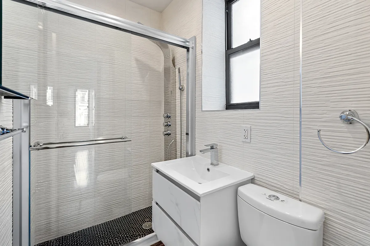 152 Thompson Street, Unit 5E Manhattan, NY 10012 - Photo 9 of 10 a bathroom with a sink a toilet and shower