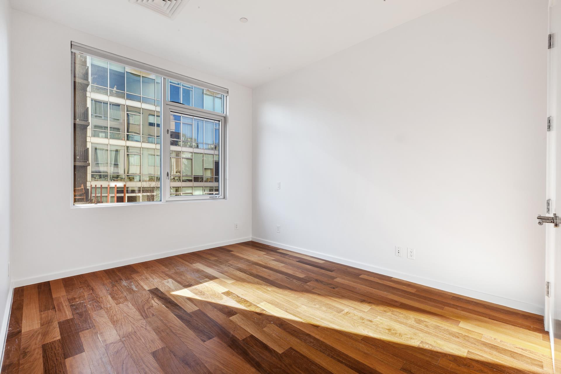 170 North 11th Street, Unit 3F Brooklyn, NY 11211 - Photo 5 of 9 a view of empty room with wooden floor and fan