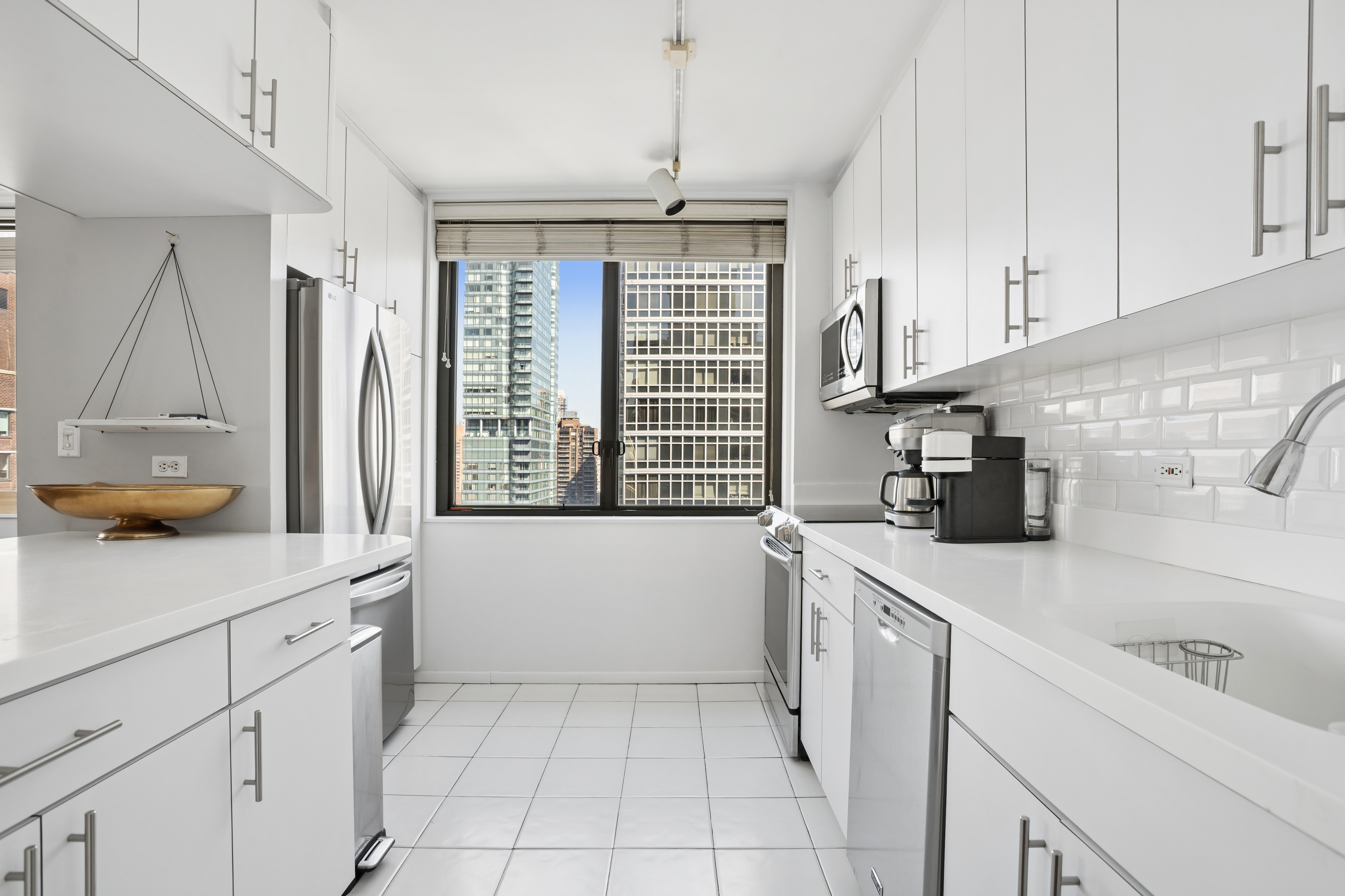 300 East 54th Street, Unit 29H Manhattan, NY 10022 - Photo 3 of 14 a kitchen with a sink a stove and cabinets