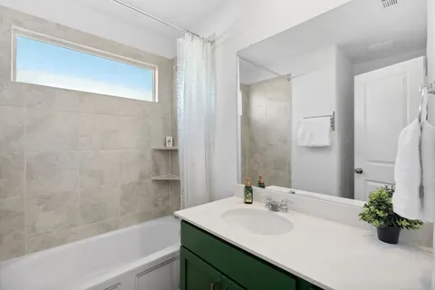 a bathroom with a bathtub sink and mirror