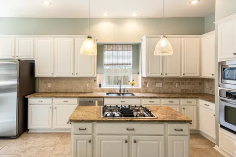 a kitchen with stainless steel appliances granite countertop a sink stove and cabinets