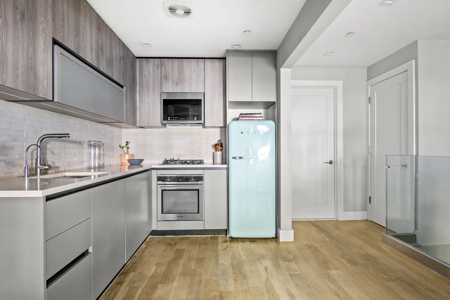 a kitchen with a sink a refrigerator and cabinets