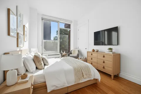 a bedroom with a bed and a flat screen tv