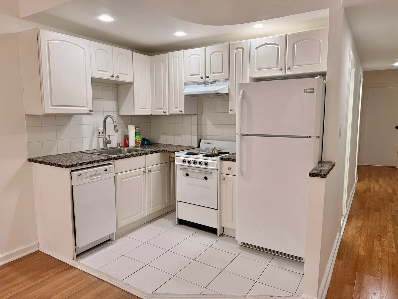 a kitchen with white cabinets and white appliances