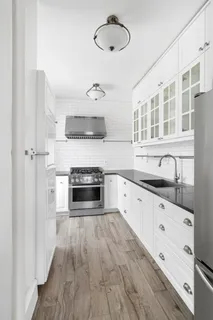a large kitchen with cabinets wooden floor and stainless steel appliances