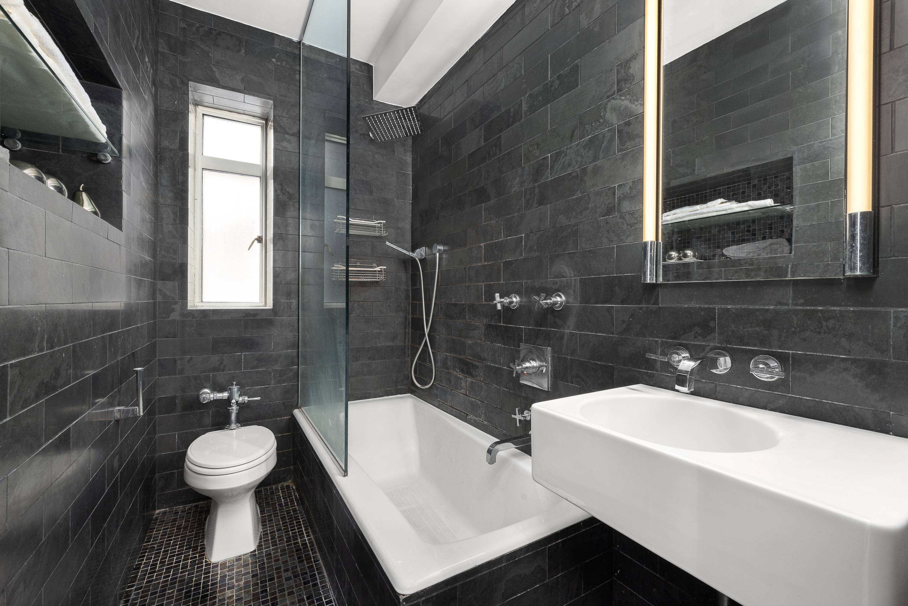 165 West 20th Street, Unit 3L Manhattan, NY 10011 - Photo 6 of 7 a bathroom with a sink a toilet a mirror and bathtub