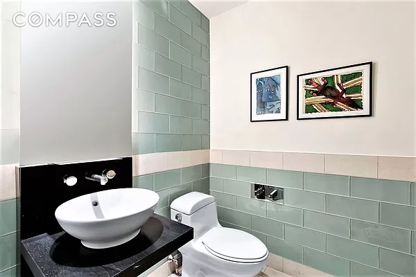 450 East 83rd Street, Unit 3A Manhattan, NY 10028 - Photo 5 of 9 a bathroom with a toilet a sink and mirror