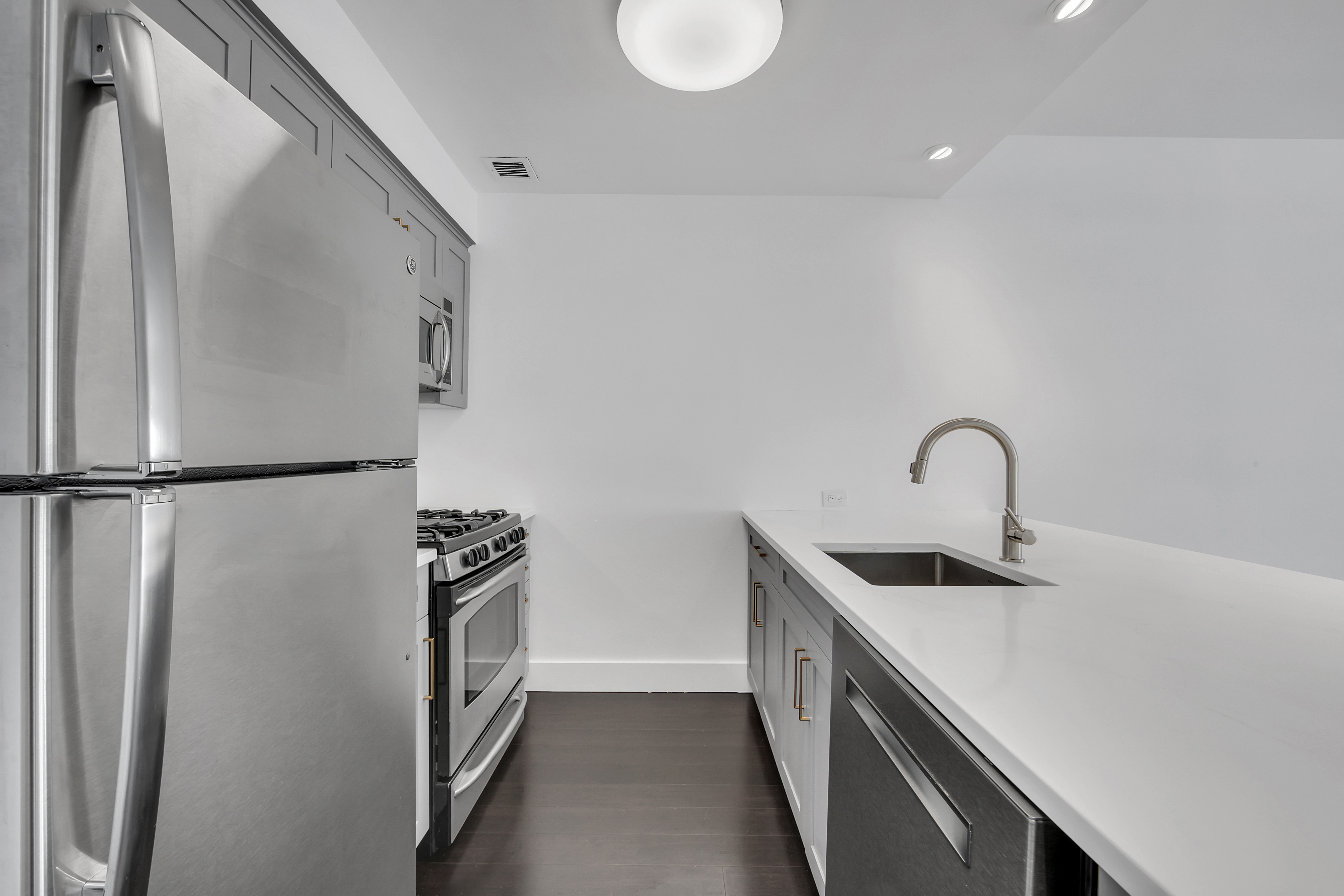 516 West 47th Street, Unit S1B Manhattan, NY 10036 - Photo 6 of 17 a kitchen with stainless steel appliances granite countertop a sink and a refrigerator