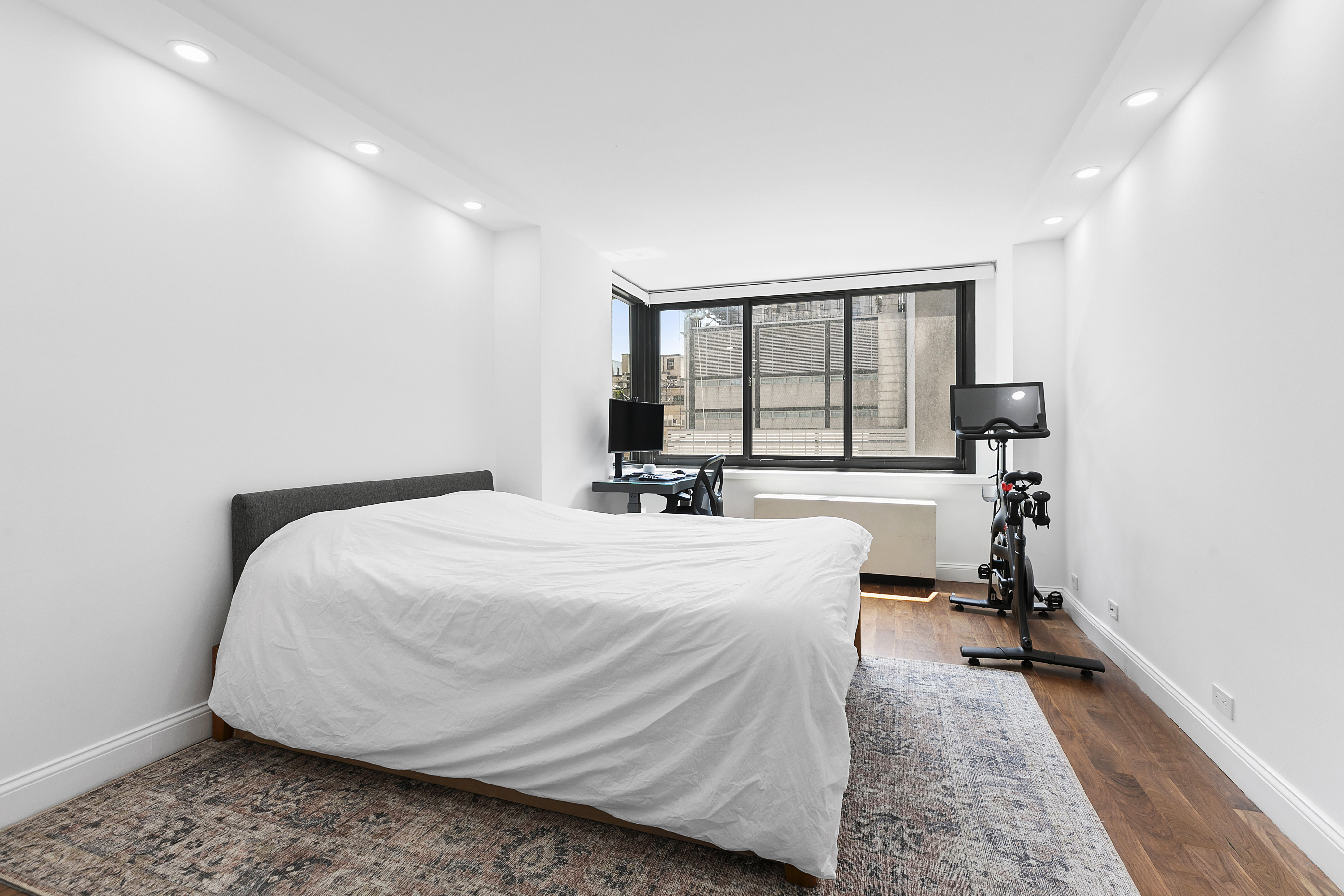 515 East 72nd Street, Unit 9J Manhattan, NY 10021 - Photo 6 of 17 a room with a bed and a large window