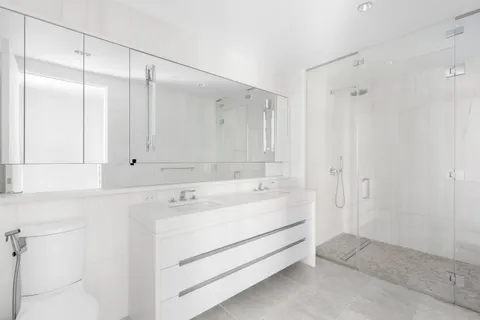 a view of bathroom with a sink mirror and shower