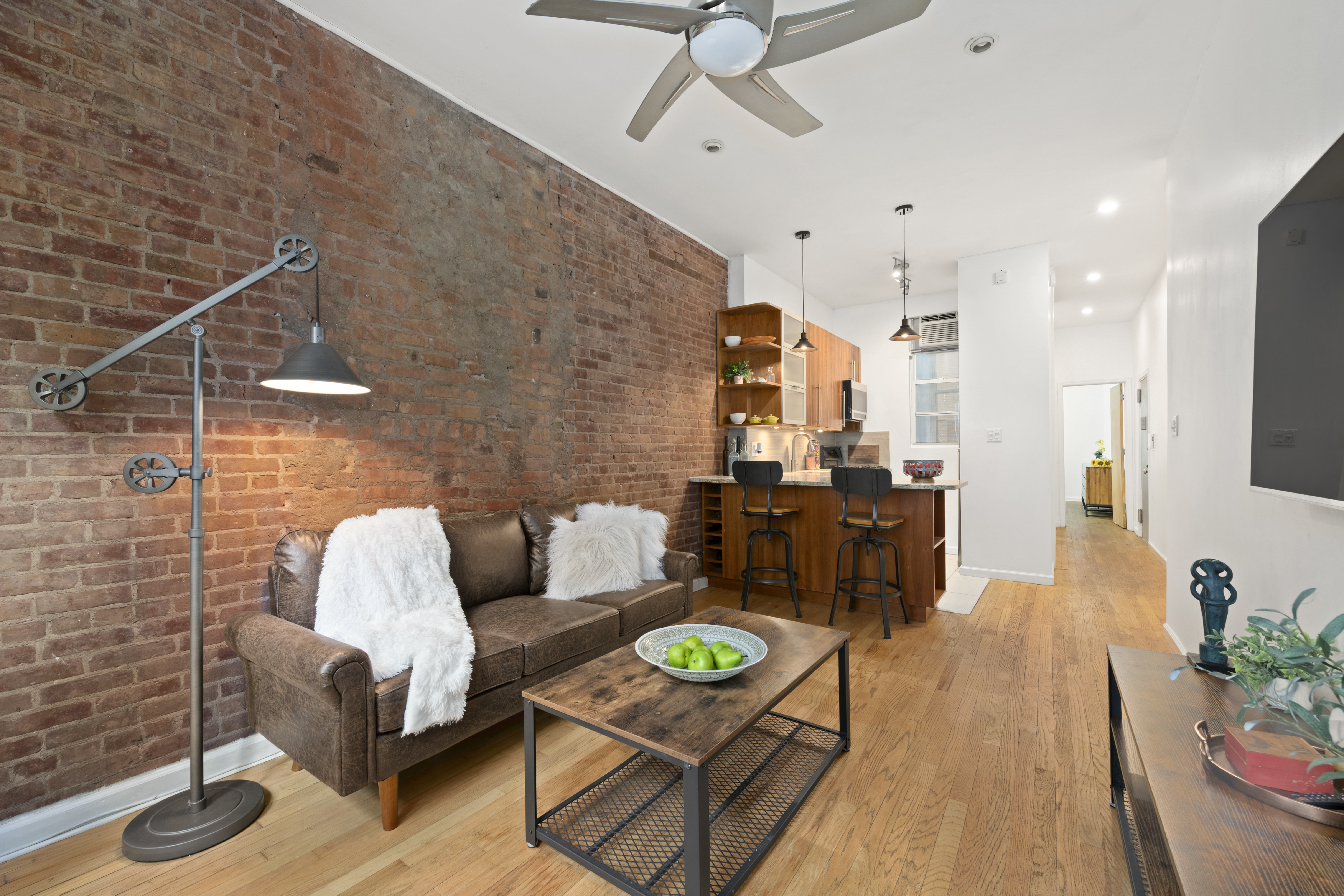 406 West 46th Street, Unit 1B Manhattan, NY 10036 - Photo 3 of 8 a living room with furniture and wooden floor