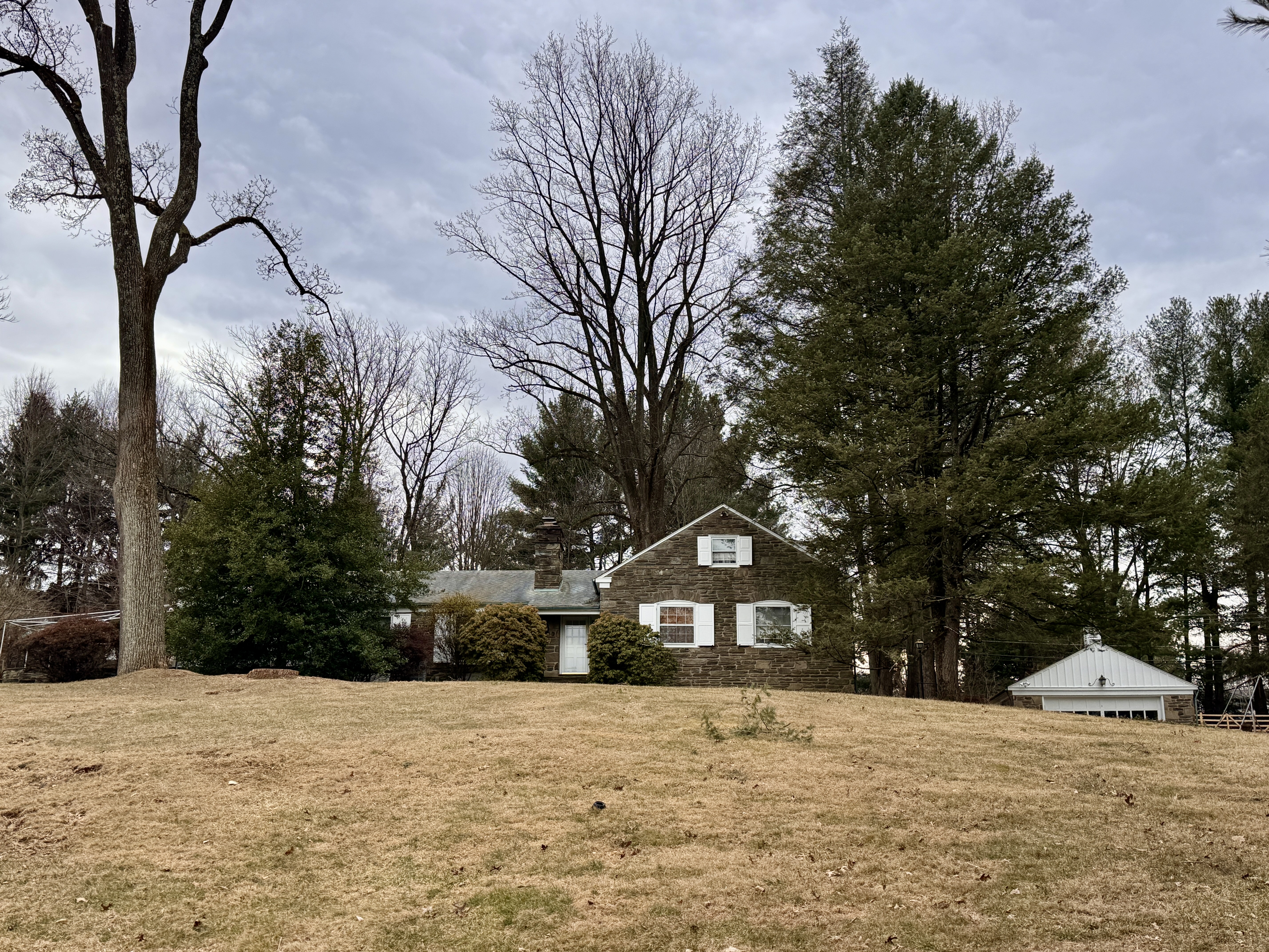 a front view of a house with a yard covered in snow