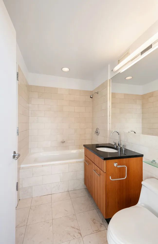 11 East 29th Street, Unit 28B Manhattan, NY 10016 - Photo 5 of 8 a bathroom with a granite countertop toilet a sink and bathtub