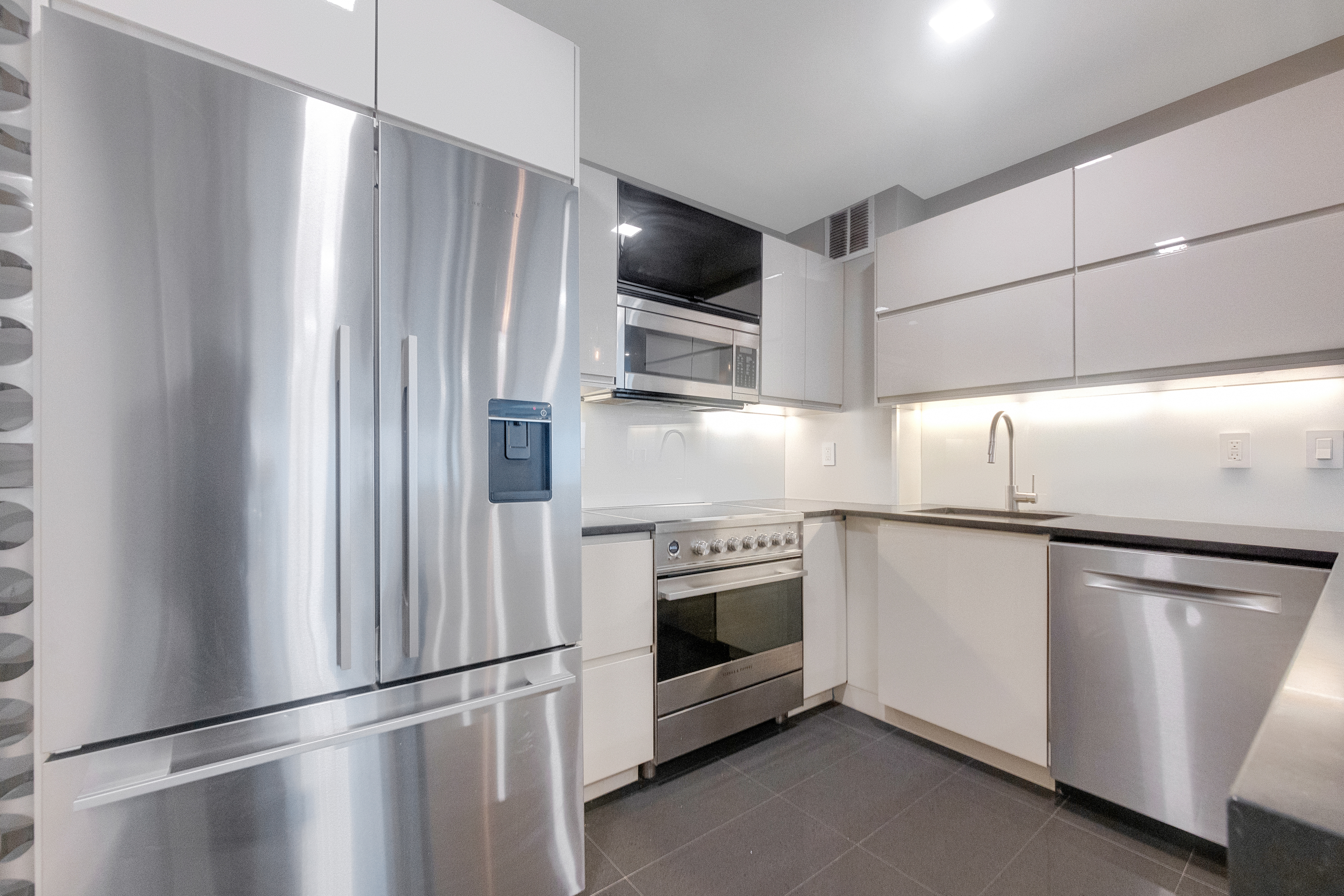 2 Tudor City Place, Unit 12DS Manhattan, NY 10017 - Photo 8 of 20 a kitchen with stainless steel appliances a refrigerator sink and microwave