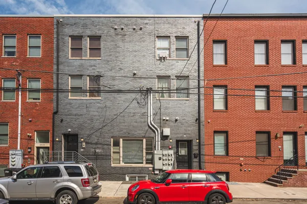 a front view of a building with cars parked