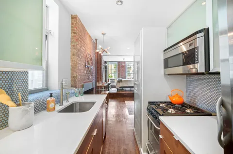 a kitchen with stainless steel appliances a stove a sink and a microwave