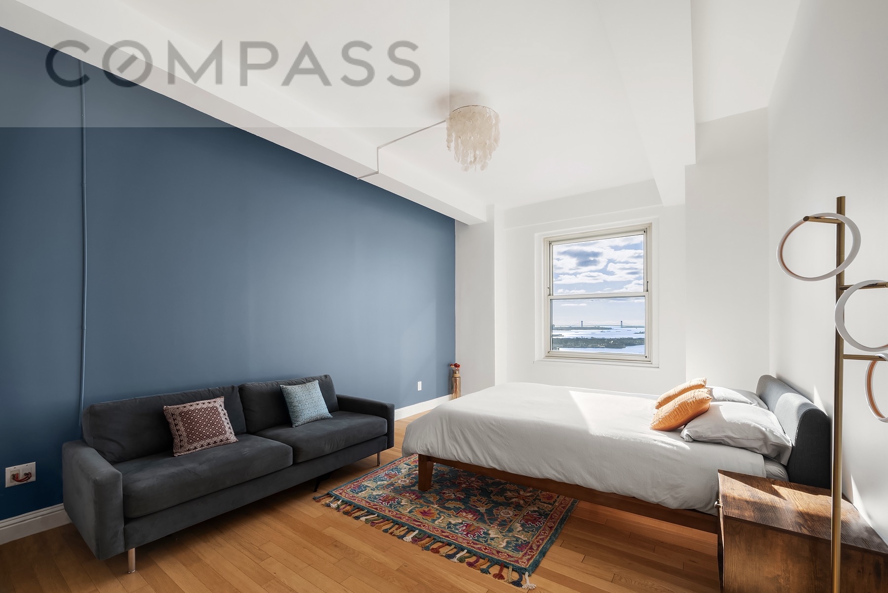 88 Greenwich Street, Unit 2903 Manhattan, NY 10006 - Photo 3 of 13 a bedroom with a bed a couch and a window