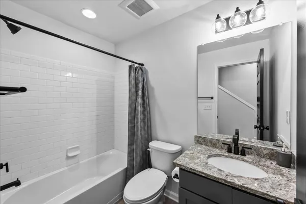 a bathroom with a granite countertop sink toilet and shower