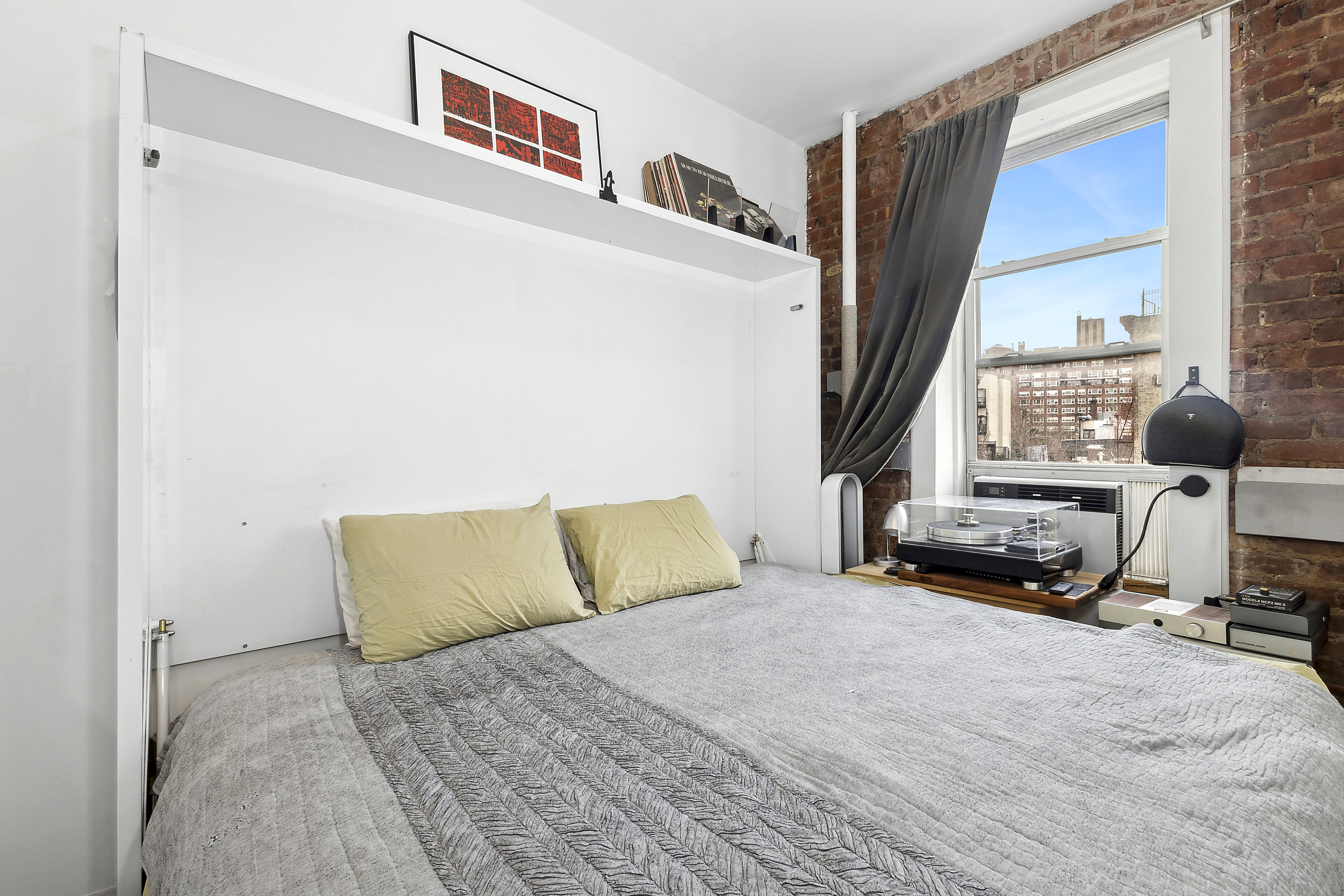 124 Thompson Street, Unit 21 Manhattan, NY 10012 - Photo 6 of 10 a bedroom with a bed and a window