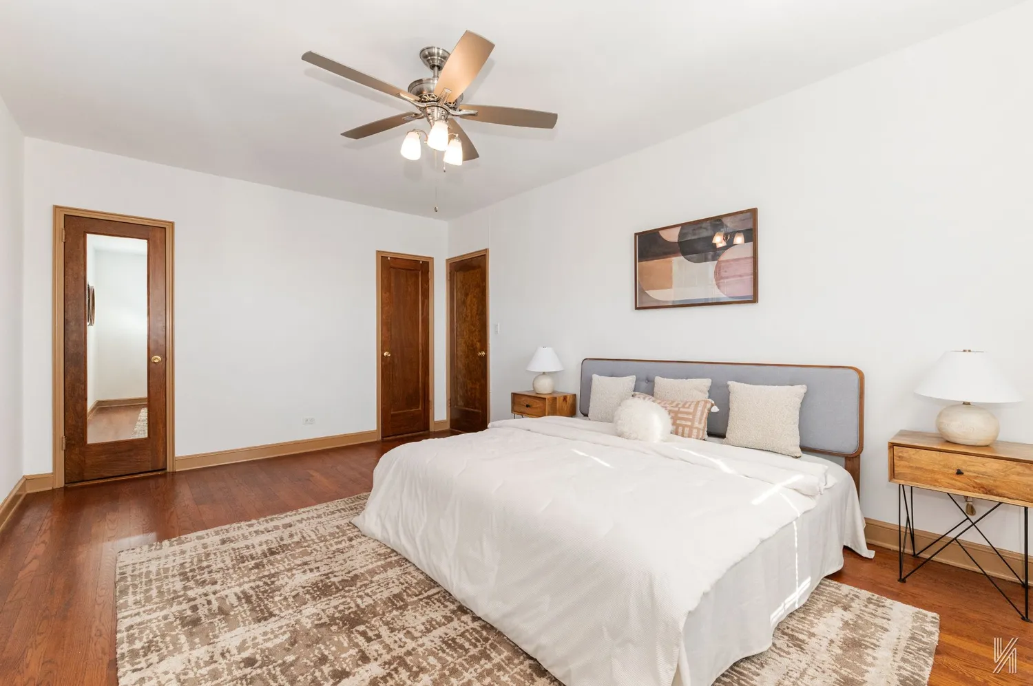 a spacious bedroom with a bed and a painting on the wall