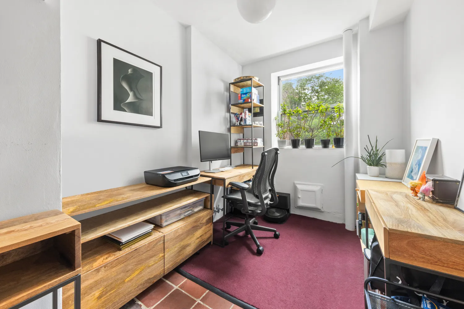 a view of a workspace with furniture and a window