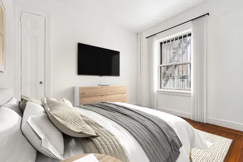 a bedroom with a bed and a flat screen tv