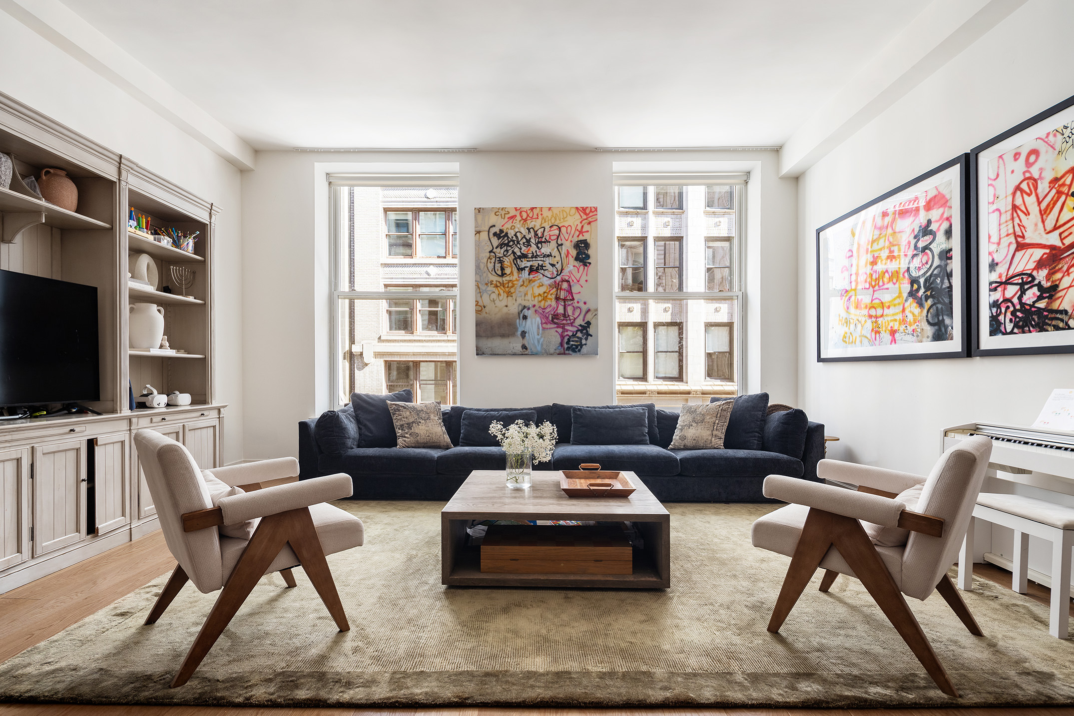 a living room with furniture a flat screen tv and a large window