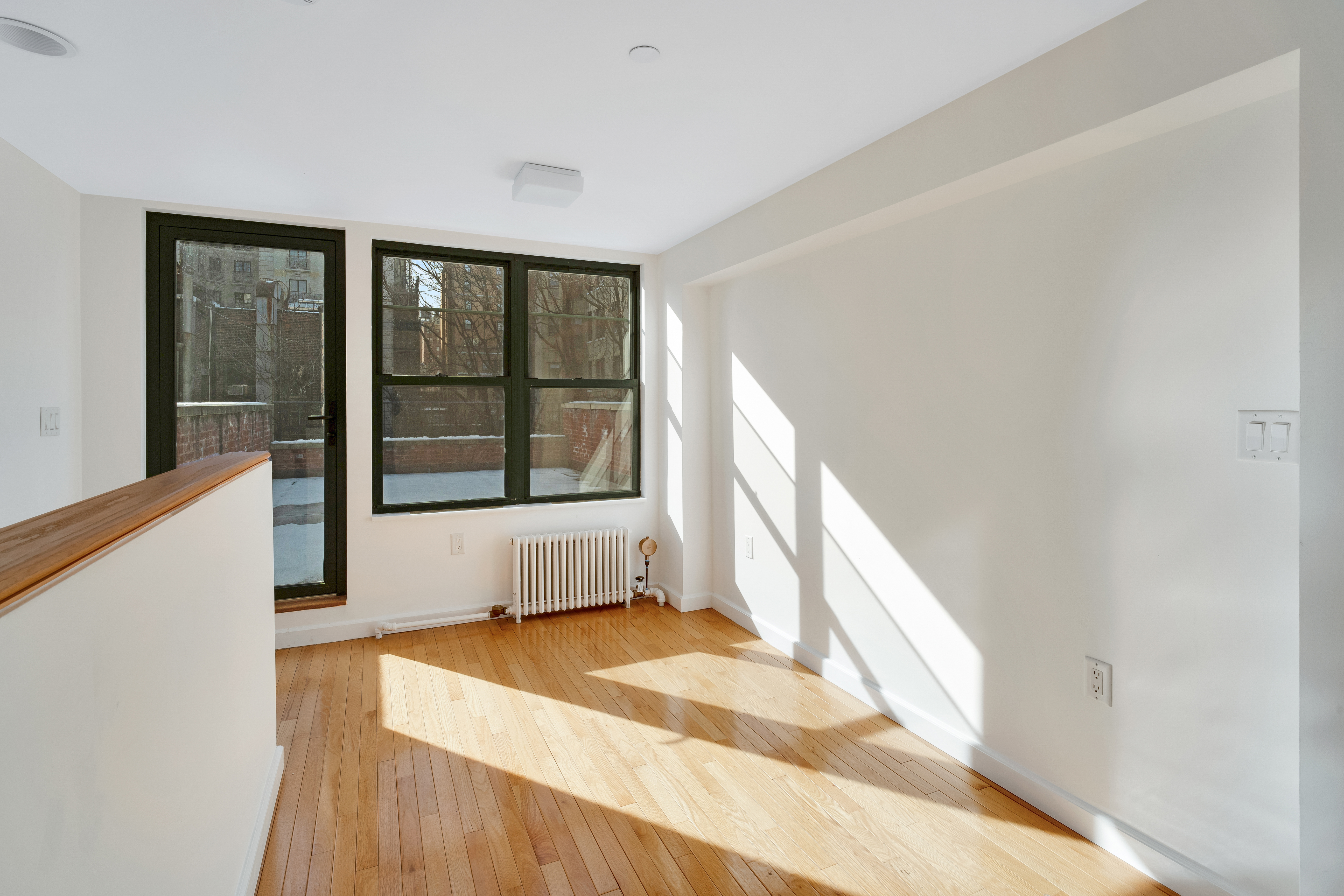 228 West 75th Street, Unit 4 Manhattan, NY 10023 - Photo 9 of 13 a view of an empty room with wooden floor and a window