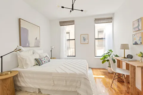 a bedroom with a bed potted plant with the outer view