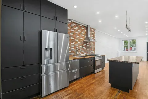 a kitchen with granite countertop a refrigerator and a stove top oven